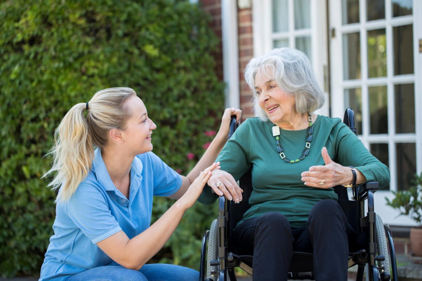 A woman sitting in a wheelchair with another person.