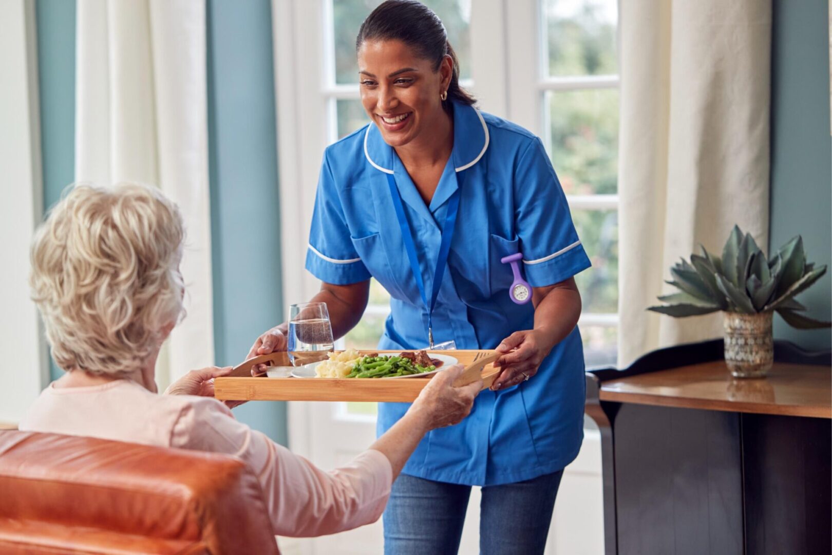 A woman serving food to an elderly person.